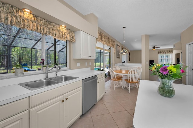 kitchen featuring light tile patterned floors, a sink, white cabinets, light countertops, and stainless steel dishwasher