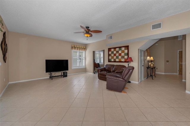 living room with light tile patterned floors, ceiling fan, a textured ceiling, and visible vents