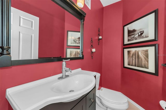 bathroom featuring visible vents, toilet, and vanity