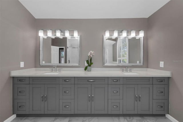 full bathroom featuring marble finish floor, a sink, and double vanity