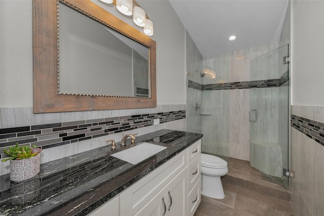 bathroom featuring tile walls, a wainscoted wall, a shower stall, and toilet