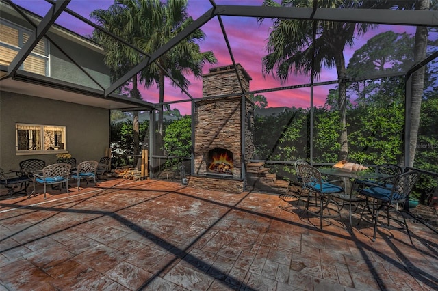 view of patio with glass enclosure, an outdoor stone fireplace, and outdoor dining area