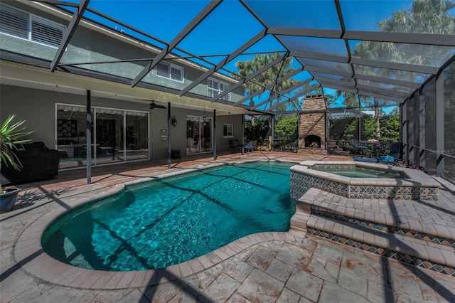 view of swimming pool with a lanai, a patio area, a fireplace, and a ceiling fan