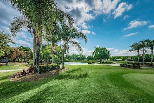 surrounding community with a yard, golf course view, and a water view