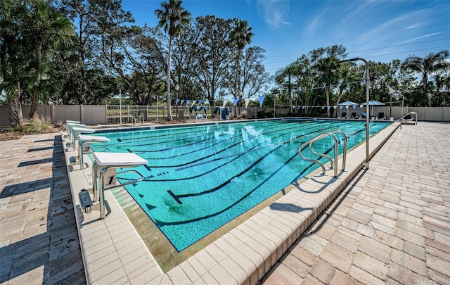 community pool with a patio and fence