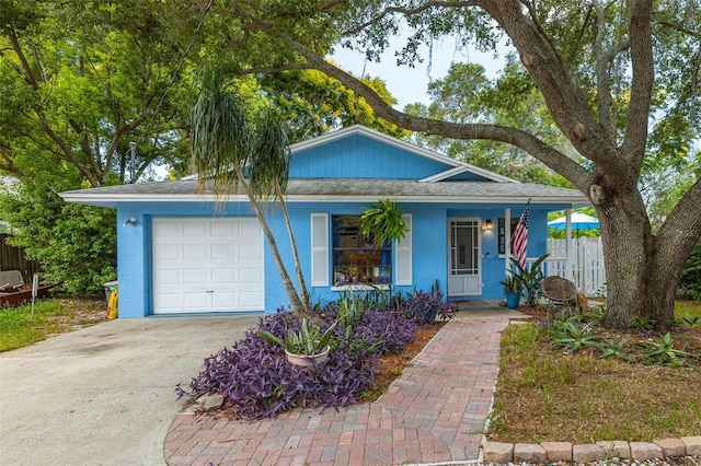 single story home featuring a garage, covered porch, driveway, and stucco siding