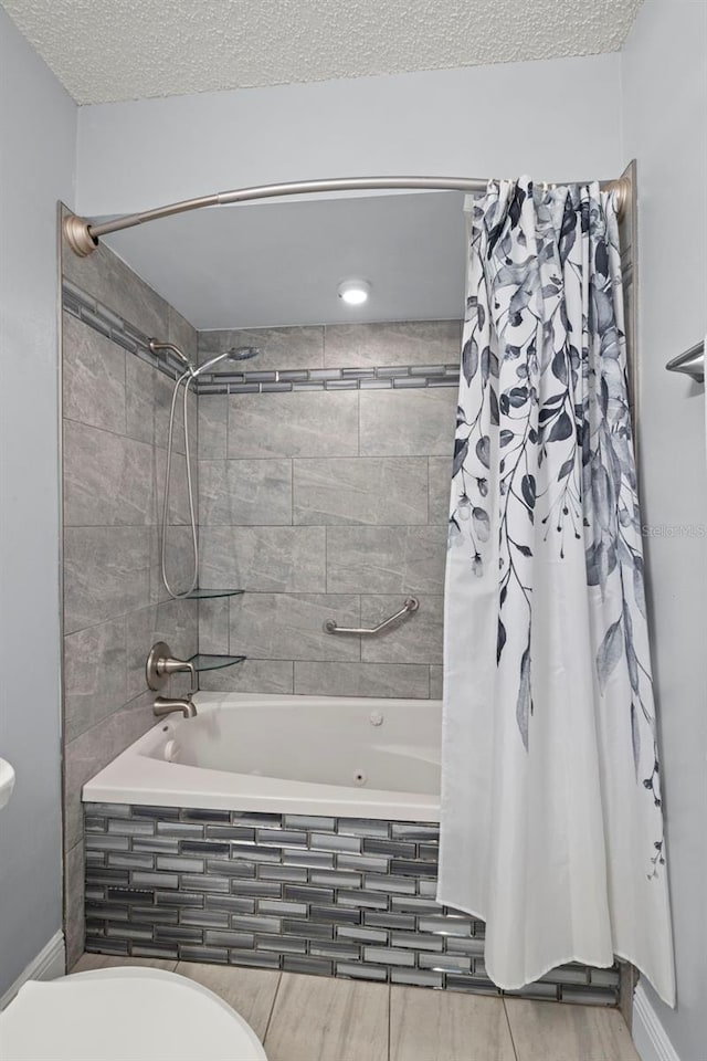 bathroom with tiled shower / bath combo, toilet, and a textured ceiling