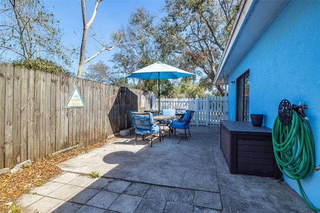 view of patio with outdoor dining area and a fenced backyard