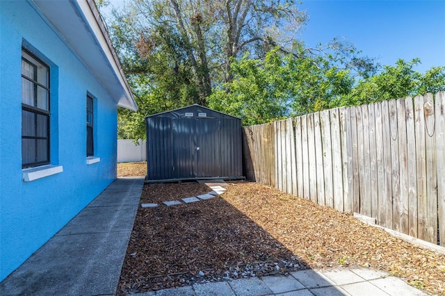 view of yard featuring a fenced backyard, an outdoor structure, and a storage unit