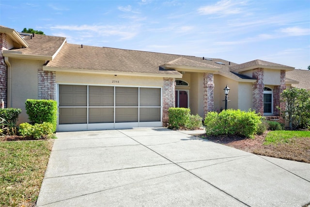 view of front facade with brick siding, concrete driveway, roof with shingles, an attached garage, and stucco siding