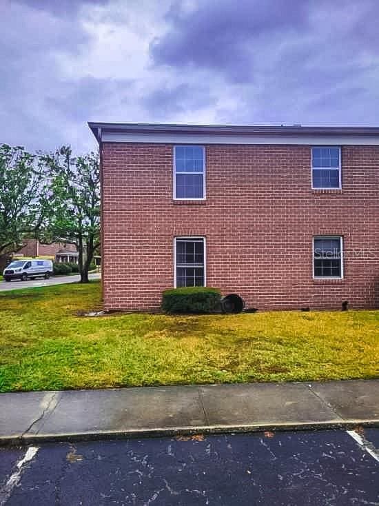 view of home's exterior featuring brick siding and a lawn