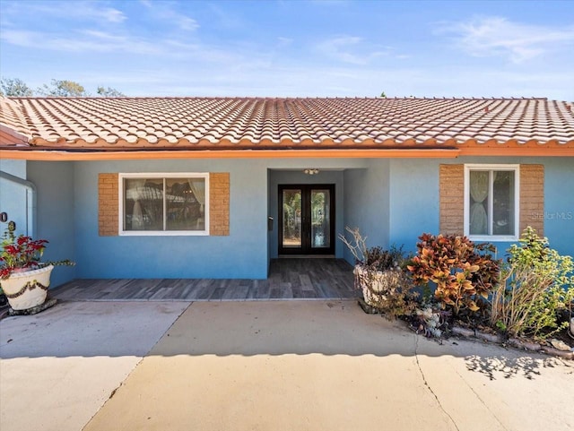 view of exterior entry with stucco siding and french doors