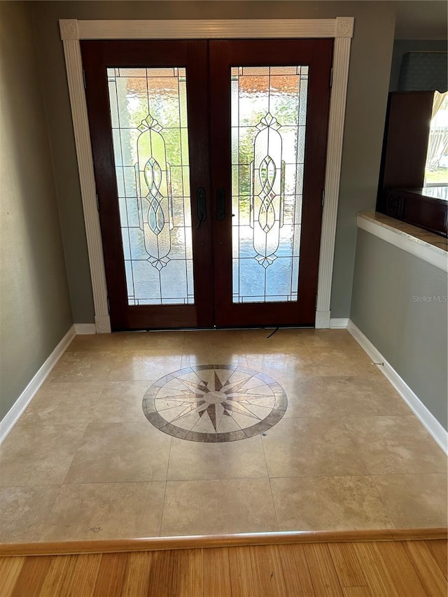 entrance foyer with baseboards and french doors