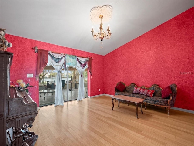 sitting room with a chandelier, baseboards, wood finished floors, and wallpapered walls