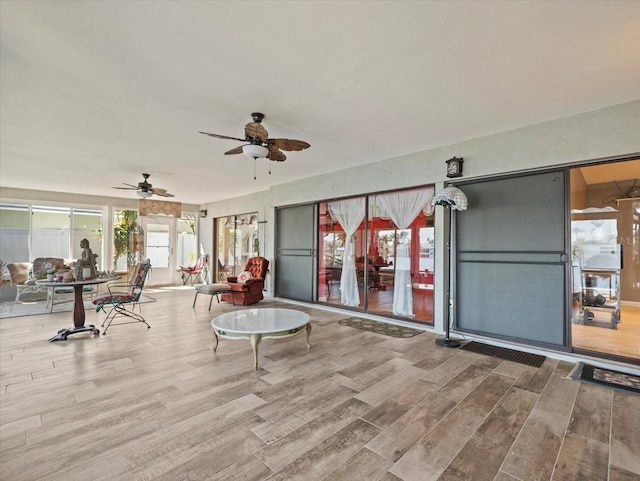 unfurnished sunroom featuring a ceiling fan