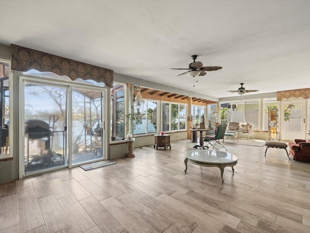 unfurnished sunroom with ceiling fan