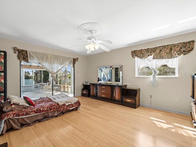 interior space with access to exterior, ceiling fan, baseboards, and light wood-style floors