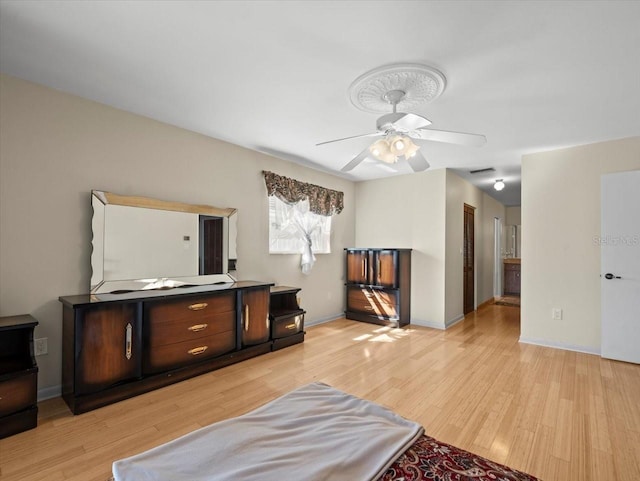 interior space featuring light wood-style floors, visible vents, baseboards, and a ceiling fan