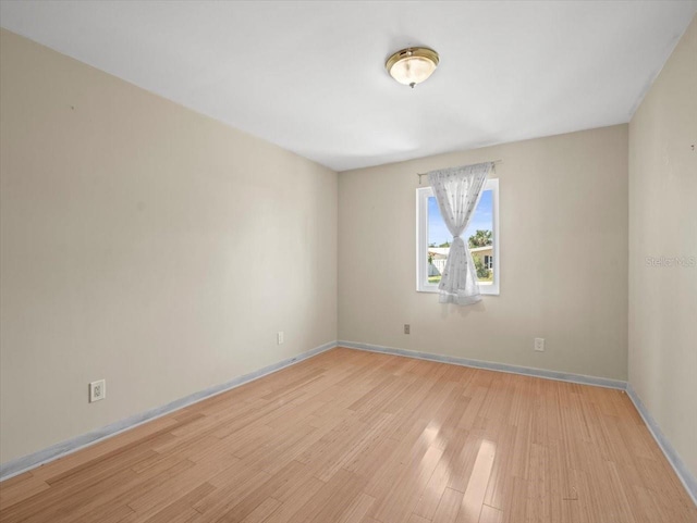 empty room with baseboards and light wood finished floors