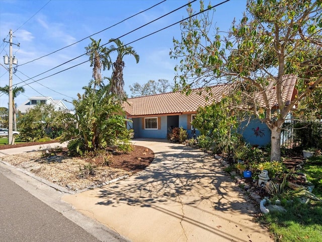 view of front of property featuring driveway, stucco siding, and a tiled roof