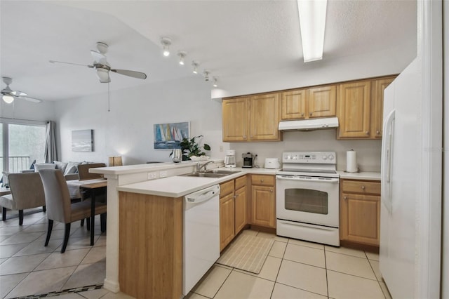 kitchen with white appliances, a peninsula, light countertops, under cabinet range hood, and a sink