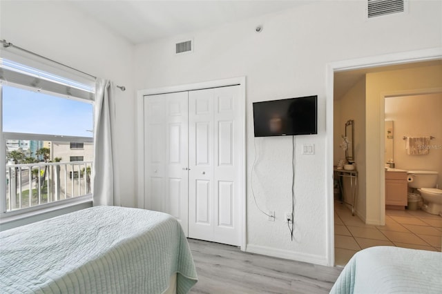 bedroom featuring light wood-style floors, a closet, visible vents, and baseboards