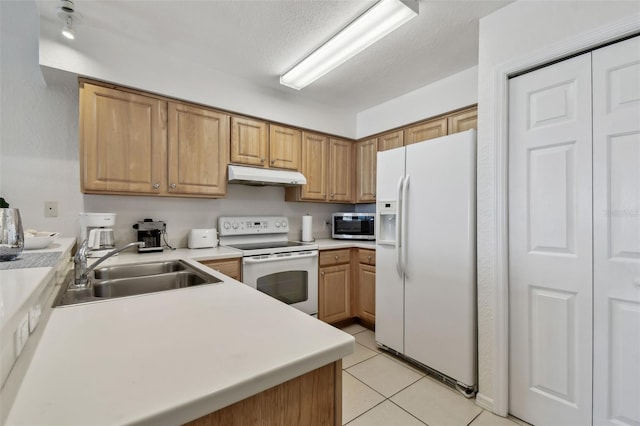 kitchen featuring light tile patterned floors, light countertops, a sink, white appliances, and under cabinet range hood