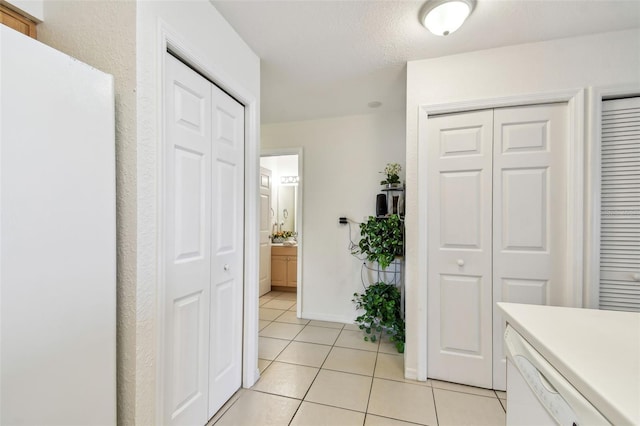 hall with baseboards and light tile patterned flooring