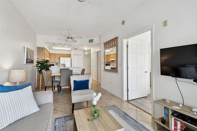 living room featuring a ceiling fan, visible vents, and light tile patterned floors