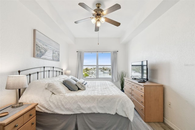 bedroom with light wood-style floors, baseboards, and a ceiling fan