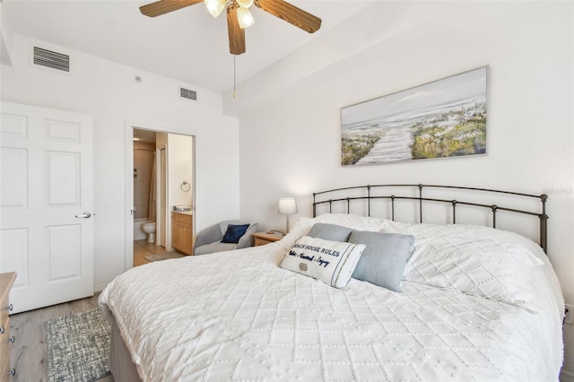 bedroom featuring light wood-type flooring, visible vents, a ceiling fan, and ensuite bathroom