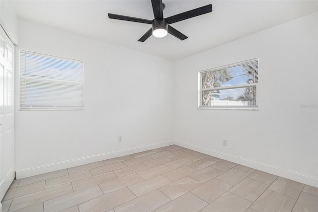 empty room featuring plenty of natural light, baseboards, and ceiling fan