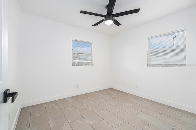 spare room featuring ceiling fan and baseboards