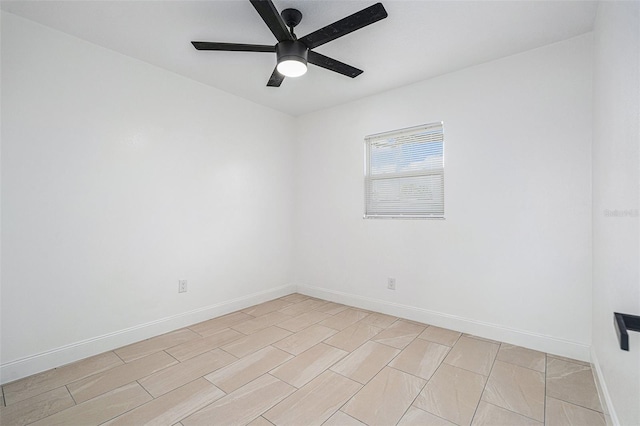 spare room featuring ceiling fan and baseboards