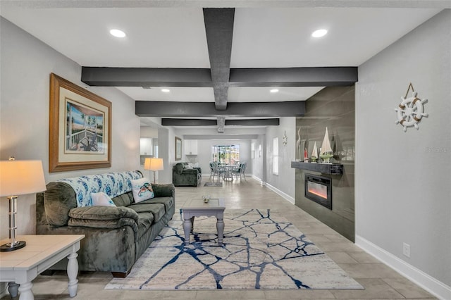 living room featuring a glass covered fireplace, beam ceiling, and baseboards