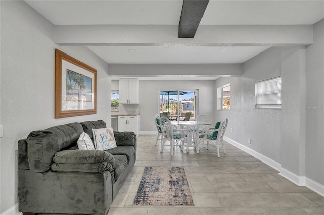 dining space with baseboards and beam ceiling