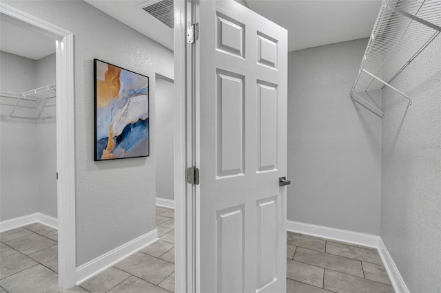 spacious closet featuring visible vents and light tile patterned floors