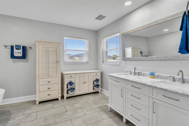 full bathroom featuring double vanity, baseboards, visible vents, tile patterned floors, and a sink