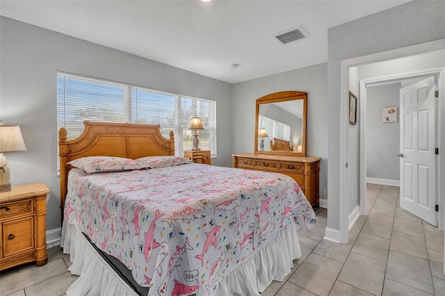 bedroom with light tile patterned floors, baseboards, and visible vents