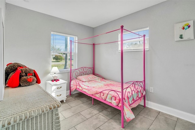 bedroom featuring light tile patterned flooring and baseboards