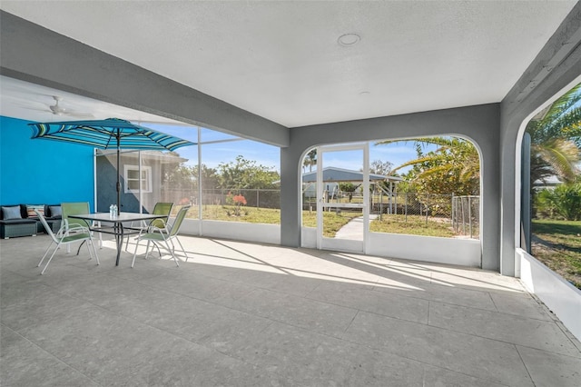 unfurnished sunroom with a ceiling fan