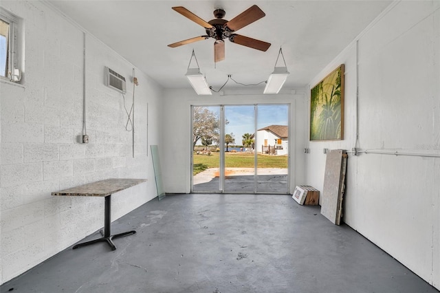 interior space featuring a ceiling fan, concrete flooring, and a wall mounted air conditioner