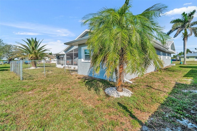 view of property exterior with a lawn and fence