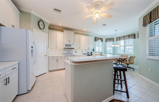 kitchen featuring light countertops, white appliances, and white cabinetry