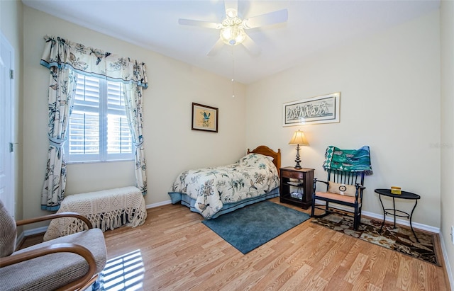 bedroom featuring light wood-style floors, baseboards, and a ceiling fan