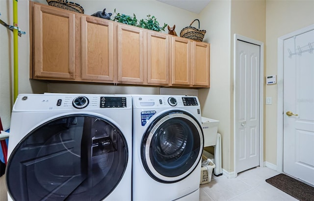 washroom with washing machine and dryer, cabinet space, baseboards, and light tile patterned flooring