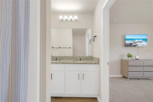 bathroom featuring double vanity, a sink, and baseboards