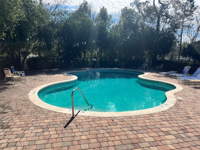 pool with fence and a patio