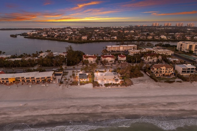 aerial view at dusk featuring a water view and a city view