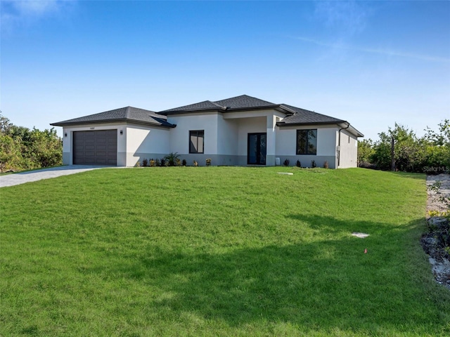 prairie-style house with concrete driveway, stucco siding, an attached garage, and a front yard